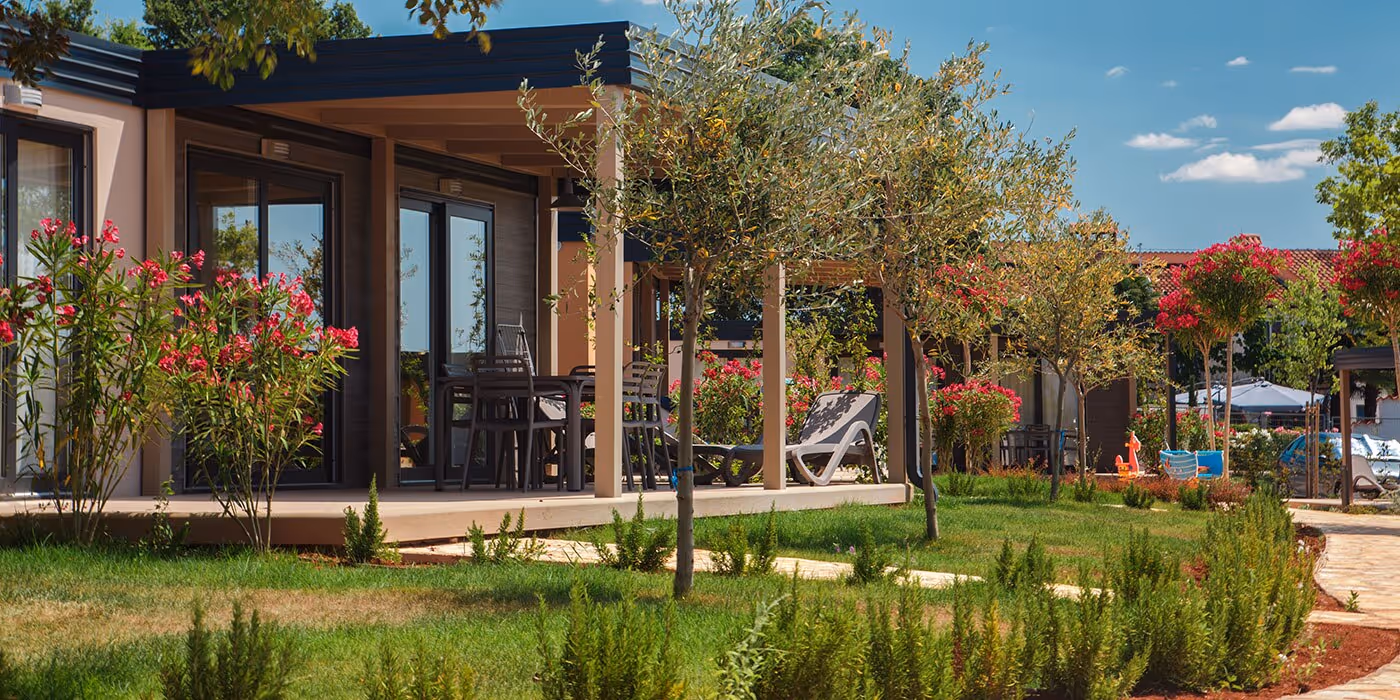 Mediterranean Garden Homes omgeven door bloeiende mediterrane beplanting op Camping Lanterna