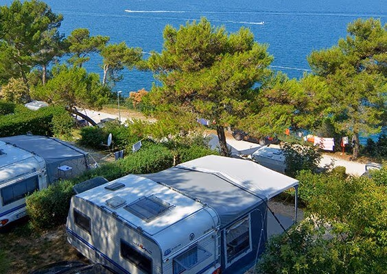 Comfort Mare-plaats met caravan onder pijnbomen en uitzicht op zee, Camping Lanterna
