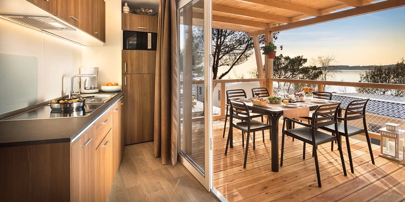 Woonkeuken en overdekt terras van een Happy Dog Home op Camping Lanterna