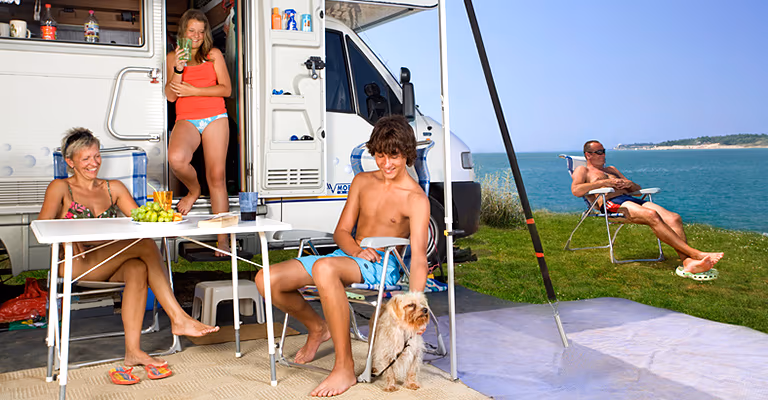 Gezin met hond bij de camper op de Happy Dog Luxury Mare staanplaats van Camping Lanterna