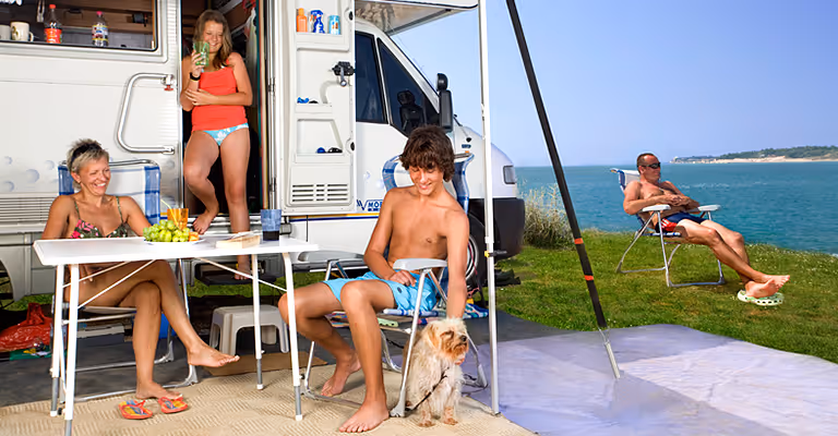 Gezin met hond bij de camper op de Happy Dog Luxury Mare staanplaats van Camping Lanterna