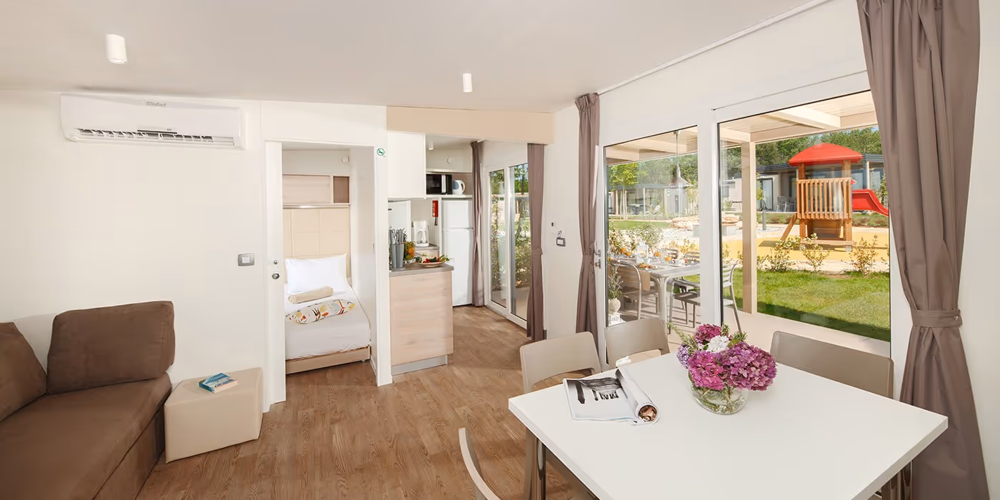Woonkamer met tuinzicht in een Mediterranean Garden Home van Camping Lanterna
