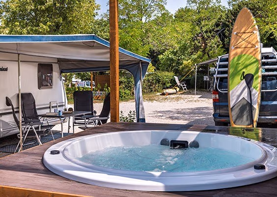 Comfort-kampeerplaats met privéjacuzzi en caravan onder de bomen, Camping Lanterna