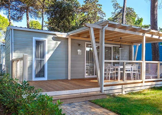 Marine Home met houten veranda tussen de bomen op Camping Lanterna