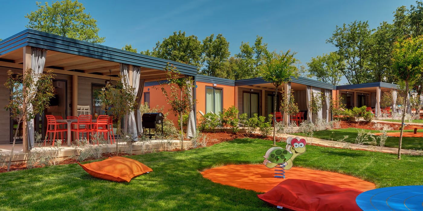 Kleurrijke Maro Homes rond een open speelveld op Camping Lanterna