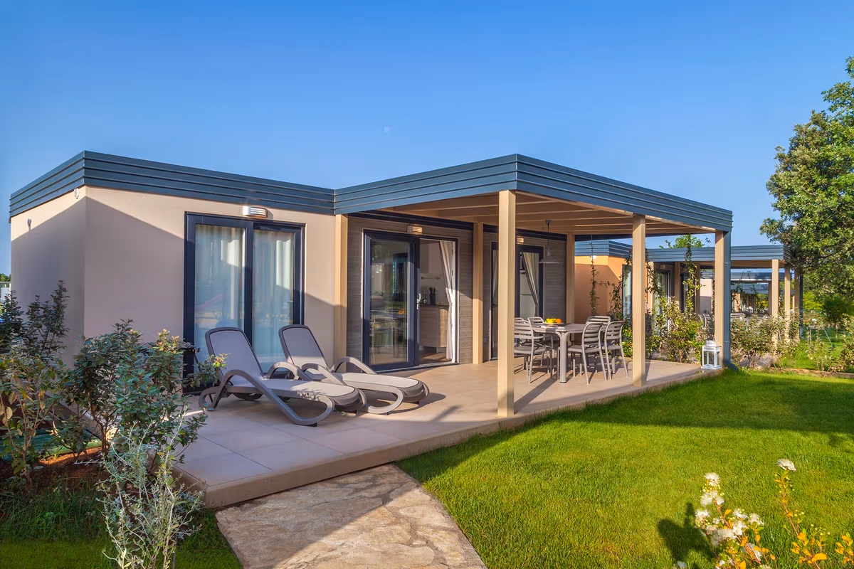 Moderne camping home met overdekt terras en ligbedden in Mediterranean Garden Village op Camping Lanterna