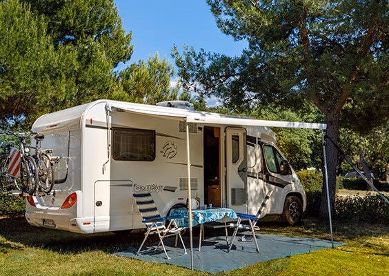 Mega Comfort-kampeerplaats met camper, fietsen en buitentafel op Camping Lanterna