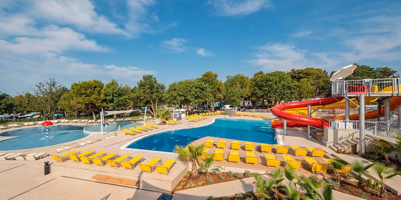 Panorama over het familiewaterpark met glijbanen en ligbedden op Camping Lanterna