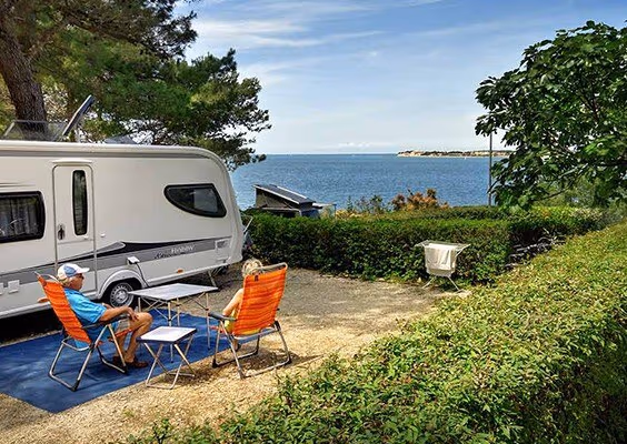 Premium Mare-kampeerplaats met caravan, zitje en zeezicht op Camping Lanterna
