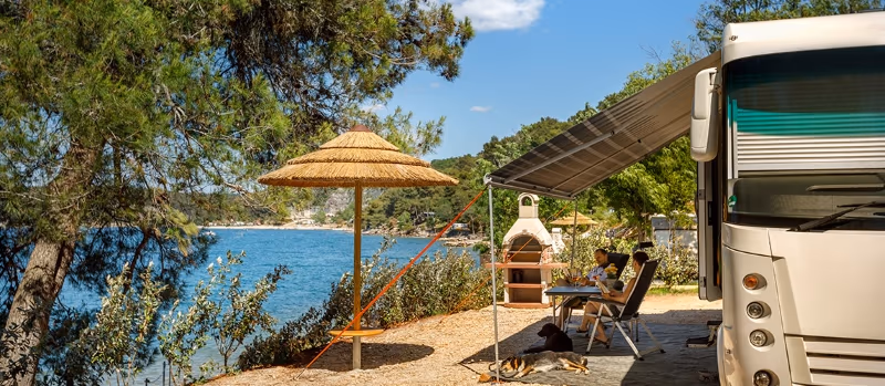 Marbello Luxury Mare XL plaats met stenen barbecue en uitzicht over de baai op Camping Lanterna