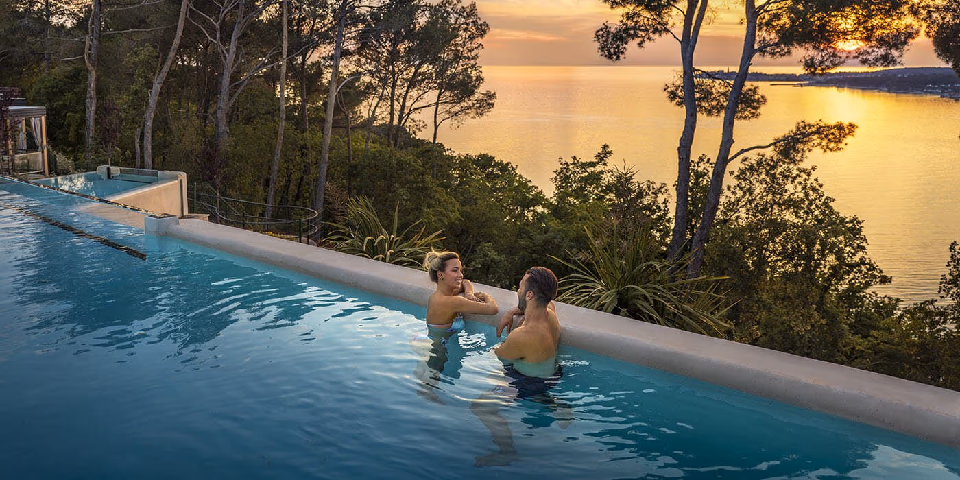 Infinityzwembad van Punto Blu bij zonsondergang op Camping Lanterna