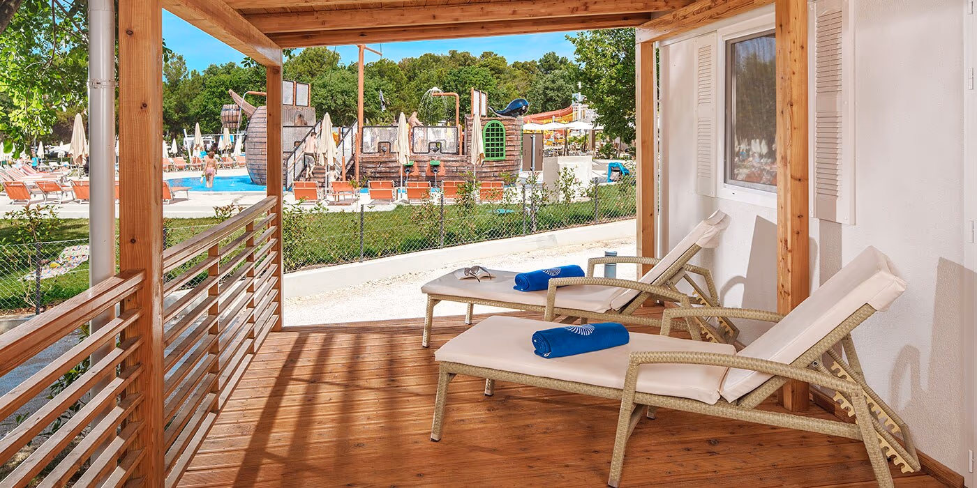 Overdekt terras met ligstoelen naast het zwembad van Istrian Village, Camping Lanterna
