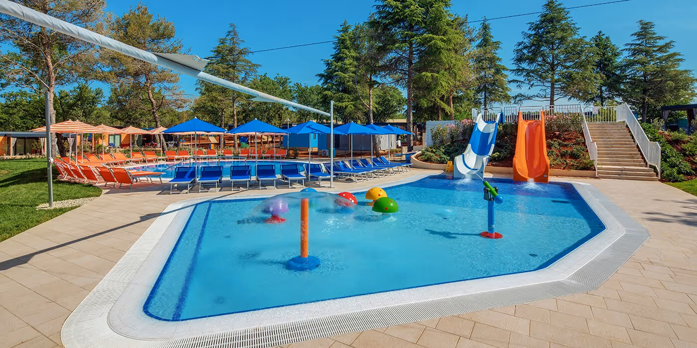 Ondiep zwembad met sproeiers en speeltoestellen in Maro Village, Camping Lanterna