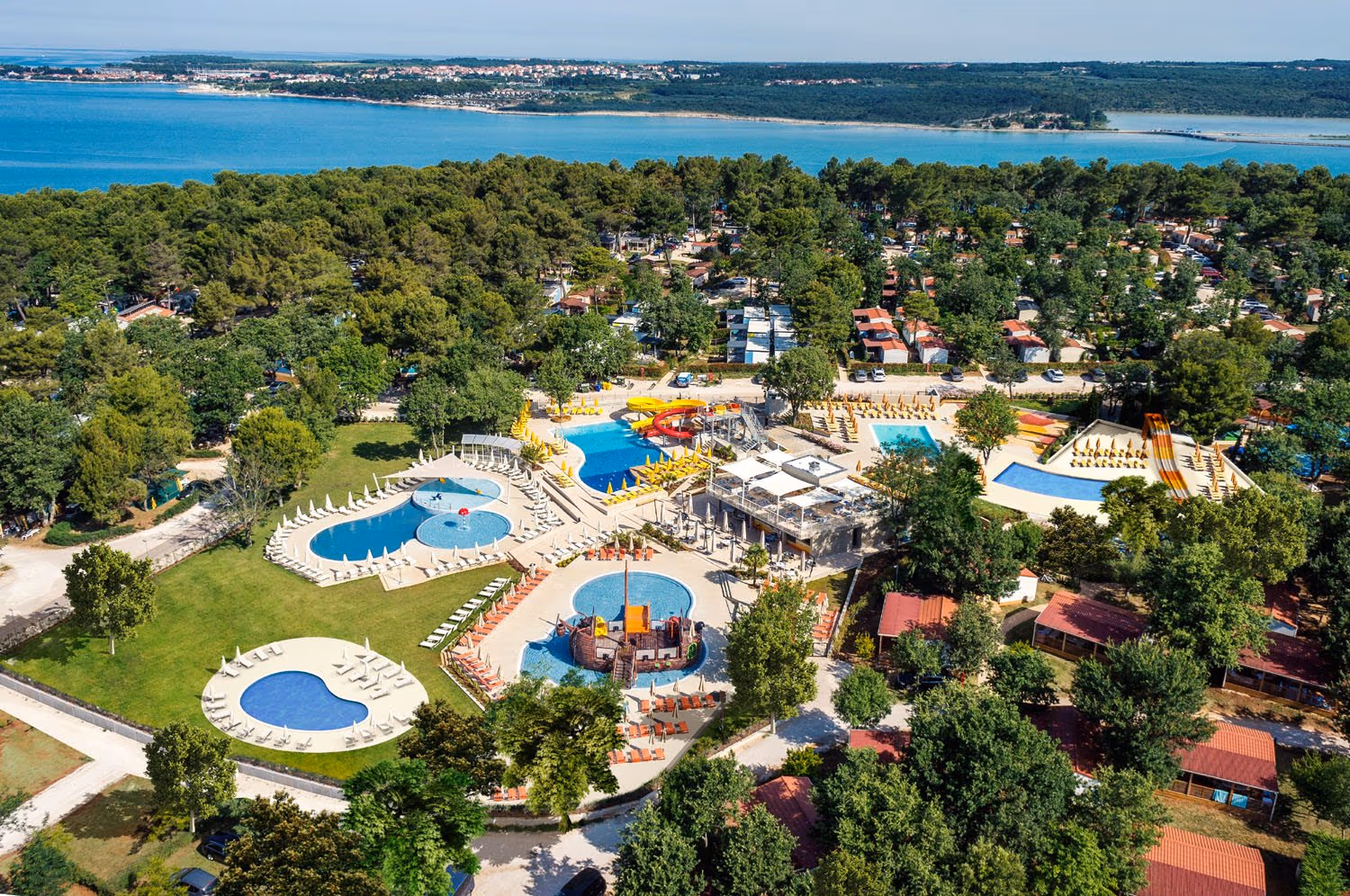 Luchtfoto van het zwembadcomplex met glijbanen en piratenschip op Camping Lanterna bij Porec