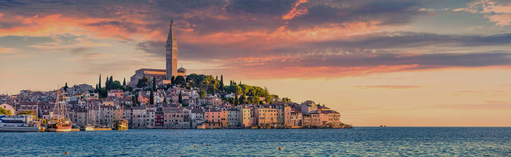 Roze avondlucht boven Rovinj, met de kerktoren als hoogste punt van de oude stad